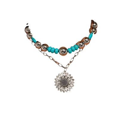 Necklace with turquoise beads and sunflower pendant on a white shirt