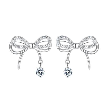 Bow-shaped earrings with dangling crystals on a white background