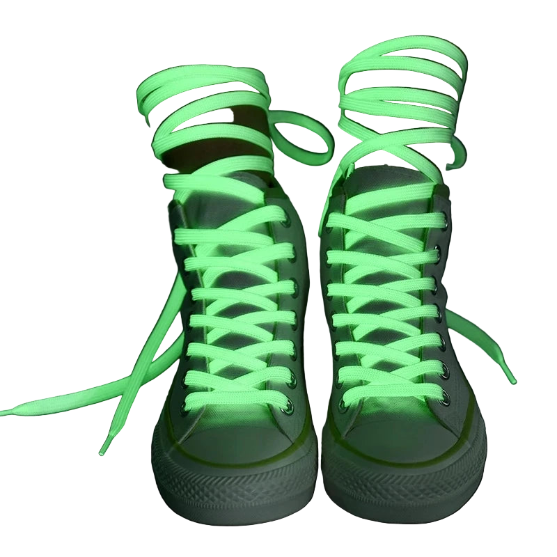 Green fluorescent shoelaces on white sneakers against a dark background