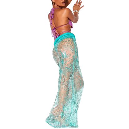 Woman wearing a purple bikini top and teal lace cover-up on a white background
