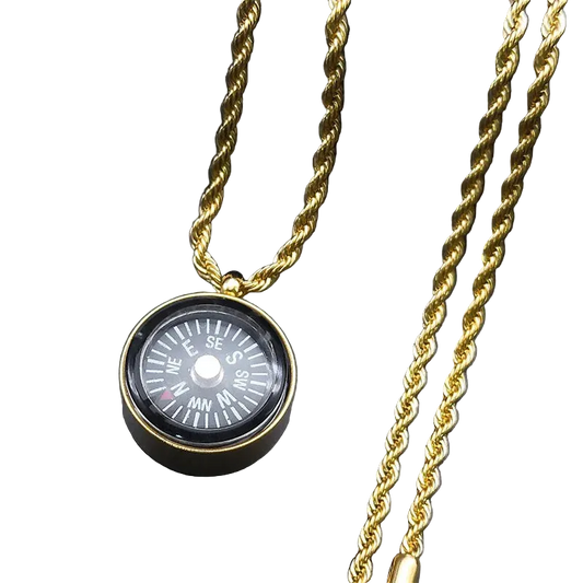 A gold-toned twisted rope chain necklace featuring a round compass pendant with a black dial and white directional markings, displayed on a dark gray background.