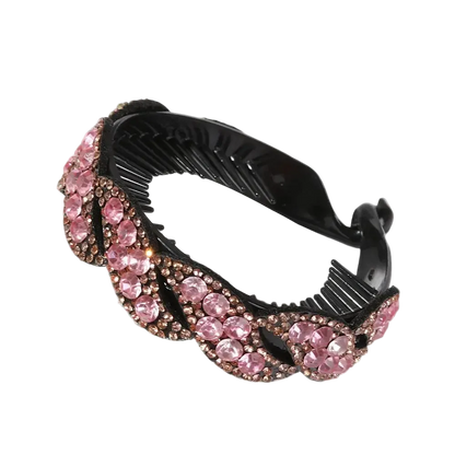 A black hair claw clip embellished with a wavy border of pink rhinestones and rose gold-toned metal settings, shown on a plain white background.