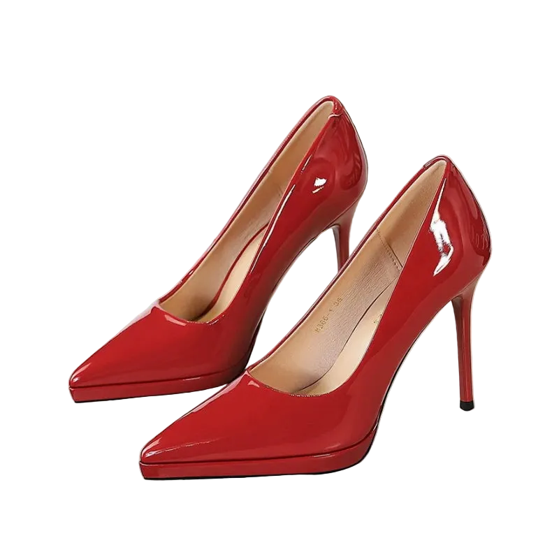 A pair of glossy red patent leather high-heeled pumps with pointed toes and slim stiletto heels, displayed on a white surface.