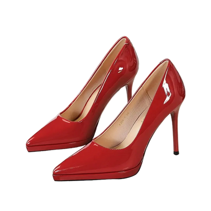 A pair of glossy red patent leather high-heeled pumps with pointed toes and slim stiletto heels, displayed on a white surface.
