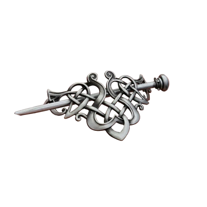 Decorative silver sword pendant held in a hand against a dark background
