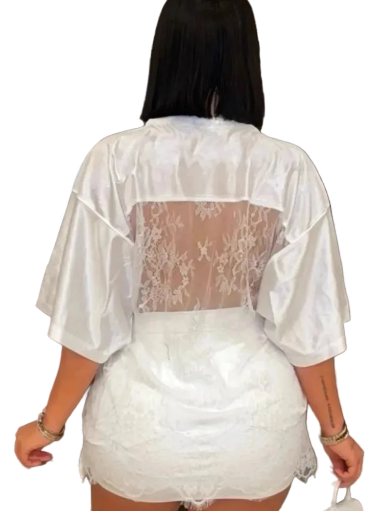 Person wearing a sheer white lace outfit with a decorative background
