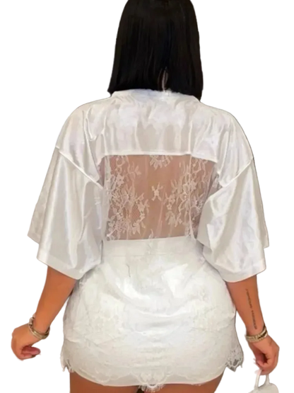 Person wearing a sheer white lace outfit with a decorative background