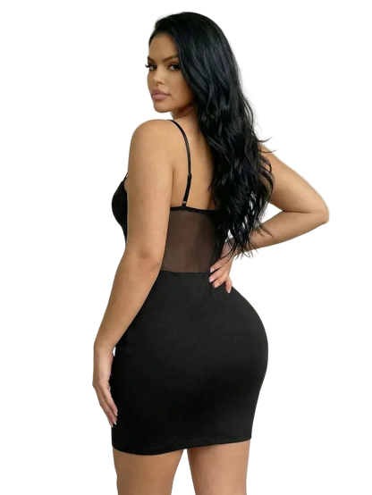 A woman modeling a black bodycon mini dress with spaghetti straps and a sheer mesh back panel, photographed against a plain light beige studio background.