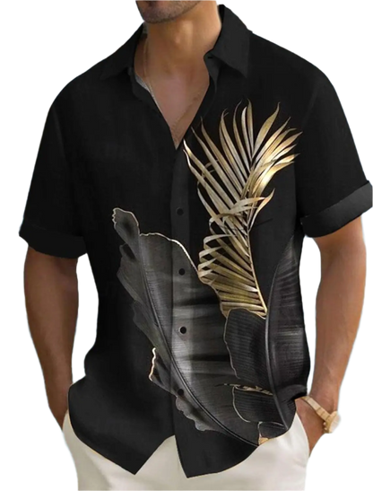Black shirt with gold leaf design worn by a person, with a blurred outdoor background.