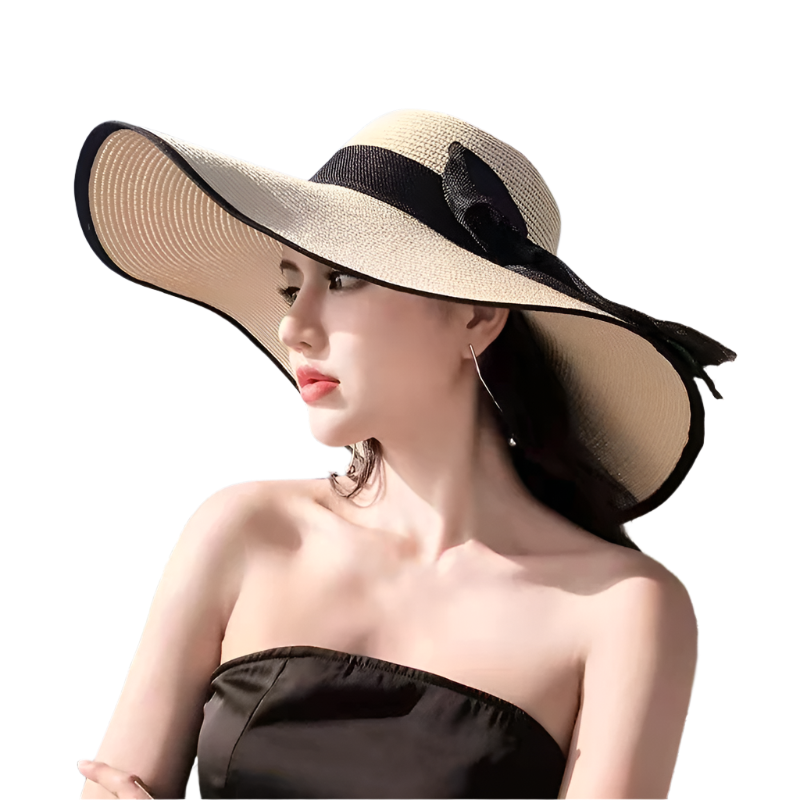 Woman wearing a large sun hat on a beach with palm trees and blue sky.