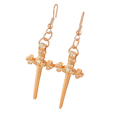 Gold earrings with a spear design on a soft pink background