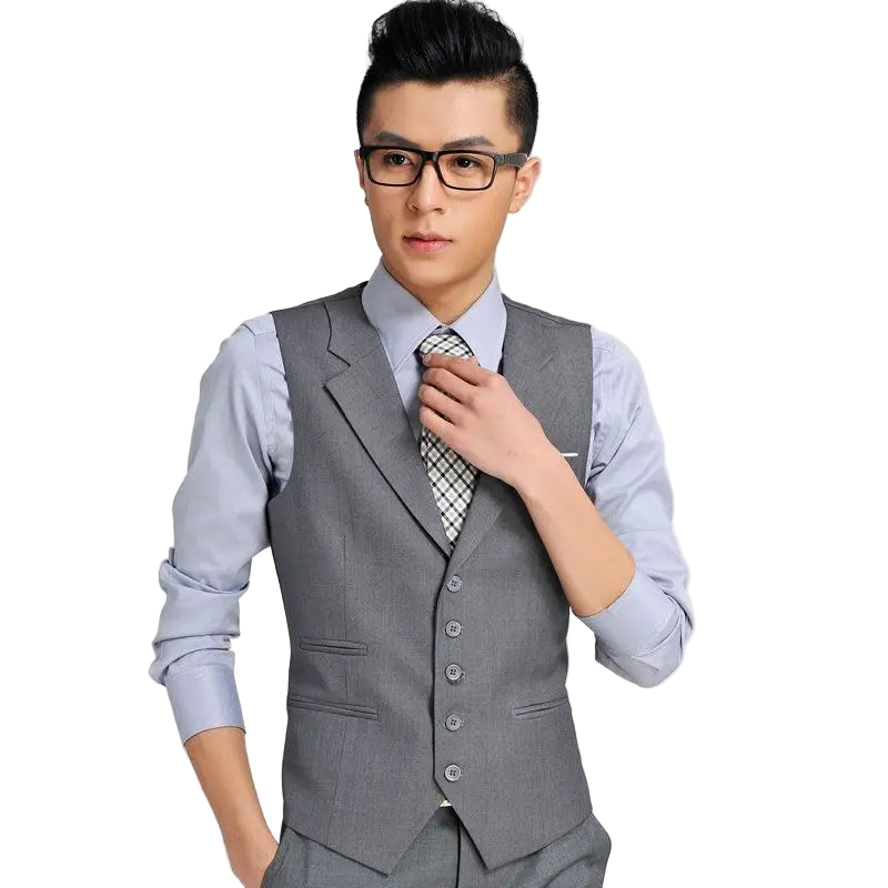 Man wearing a gray vest over a light blue shirt with a white background