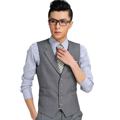 Man wearing a gray vest over a light blue shirt with a white background