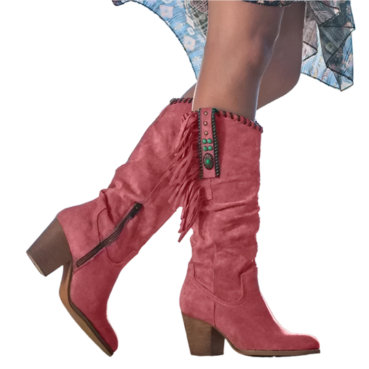 Red suede boots with fringe details on a blurred outdoor background