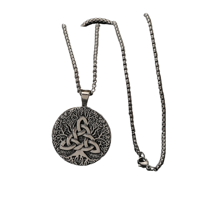 A silver Celtic knotwork pendant necklace displayed on a dark rock against a black reflective surface.