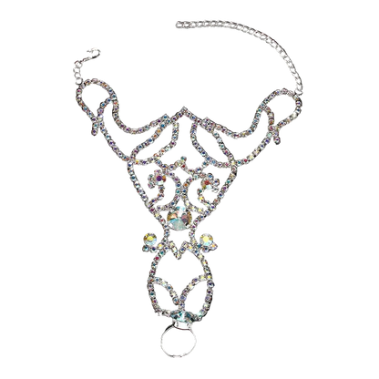 A silver-toned belly ring adorned with intricate rhinestone filigree and a large iridescent center crystal, displayed on a dark reflective surface.