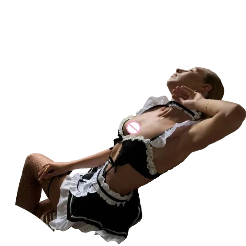 A woman reclining in a wicker chair indoors, wearing a black and white frilly maid-style lingerie outfit with fishnet stockings. A window behind her shows greenery outside, and her chest is partially obscured by a circular privacy block.