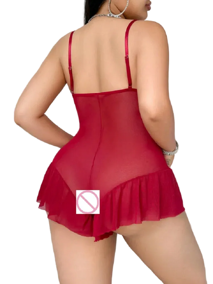 A woman shown from the back wearing a sheer red mini bodysuit with thin straps and a ruffled hem, photographed indoors against a light bedroom background.