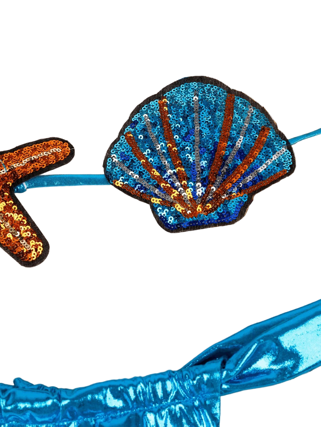 Sequined shell patch on a blue garment with a beige woven background