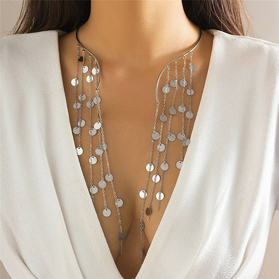 Silver chain necklace worn by a model in a white outfit