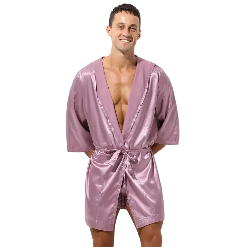 Man wearing a pink satin robe on a white background