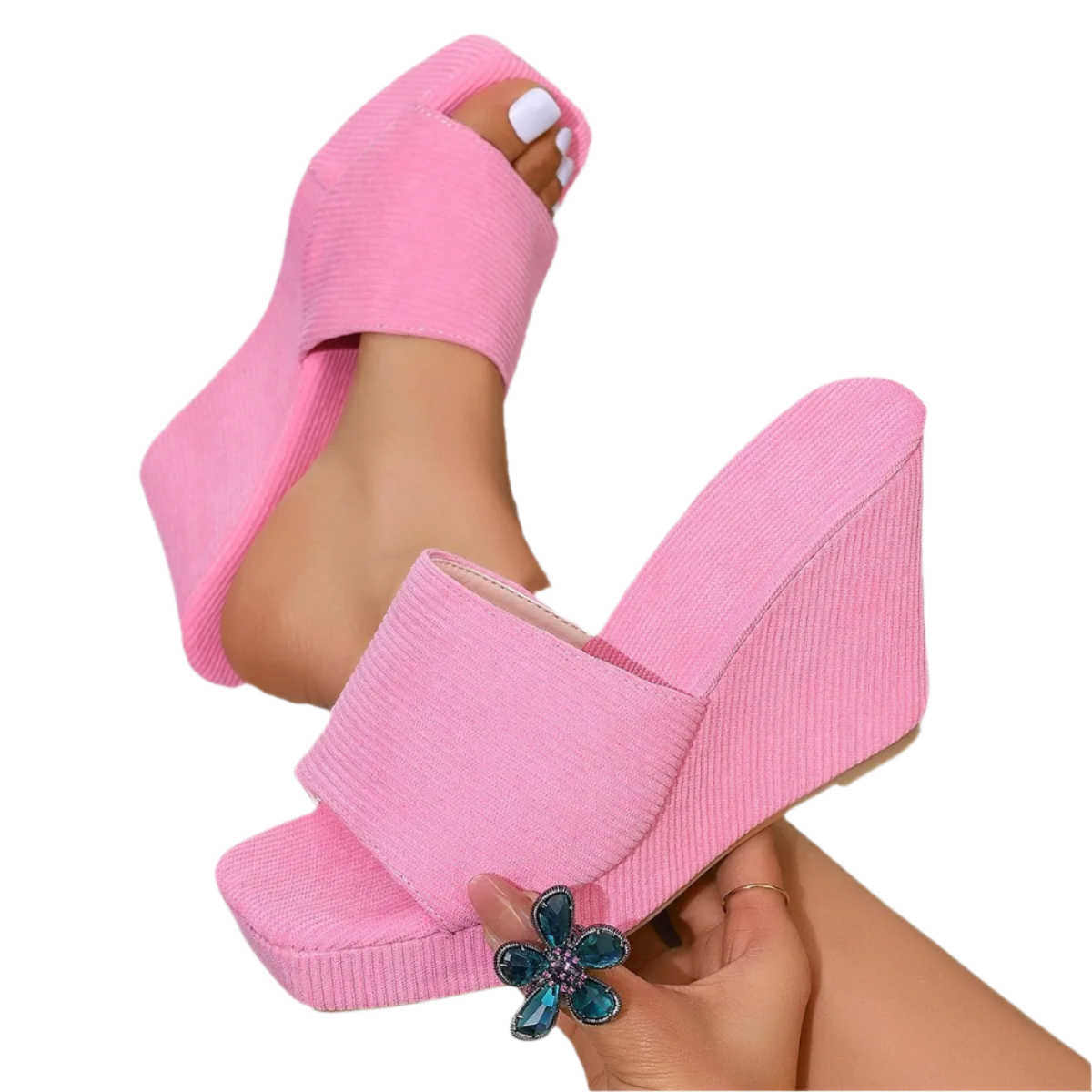 Pink wedge sandals worn with a white background