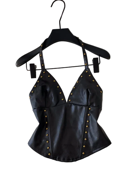 Black faux leather halter top with gold-tone studs, hanging on a black hanger against a white background.