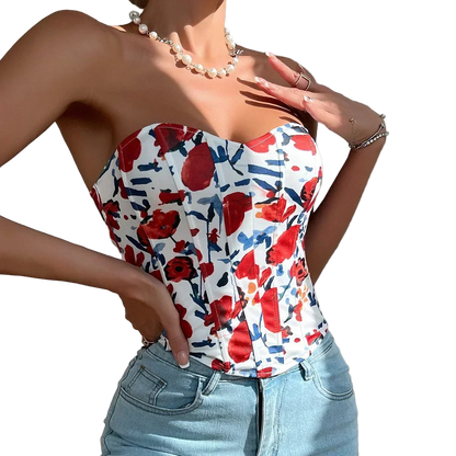 Woman wearing a strapless top with red floral pattern and light blue jeans against a neutral background