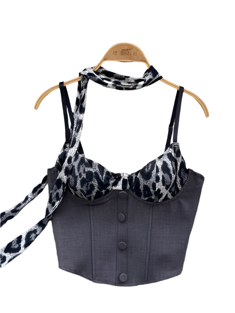 Black halter top with leopard print straps on a hanger against a floral and fur background.