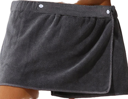 Gray towel skirt draped over a person's waist against a neutral background