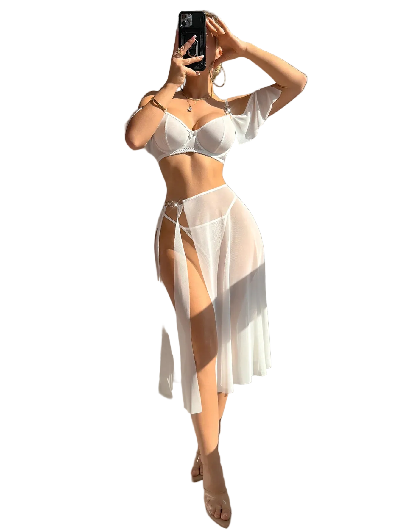 A woman takes a mirror selfie wearing a white two-piece lingerie set consisting of a bra and a sheer high-slit skirt, in a brightly lit room with strong sunlight and shadows.