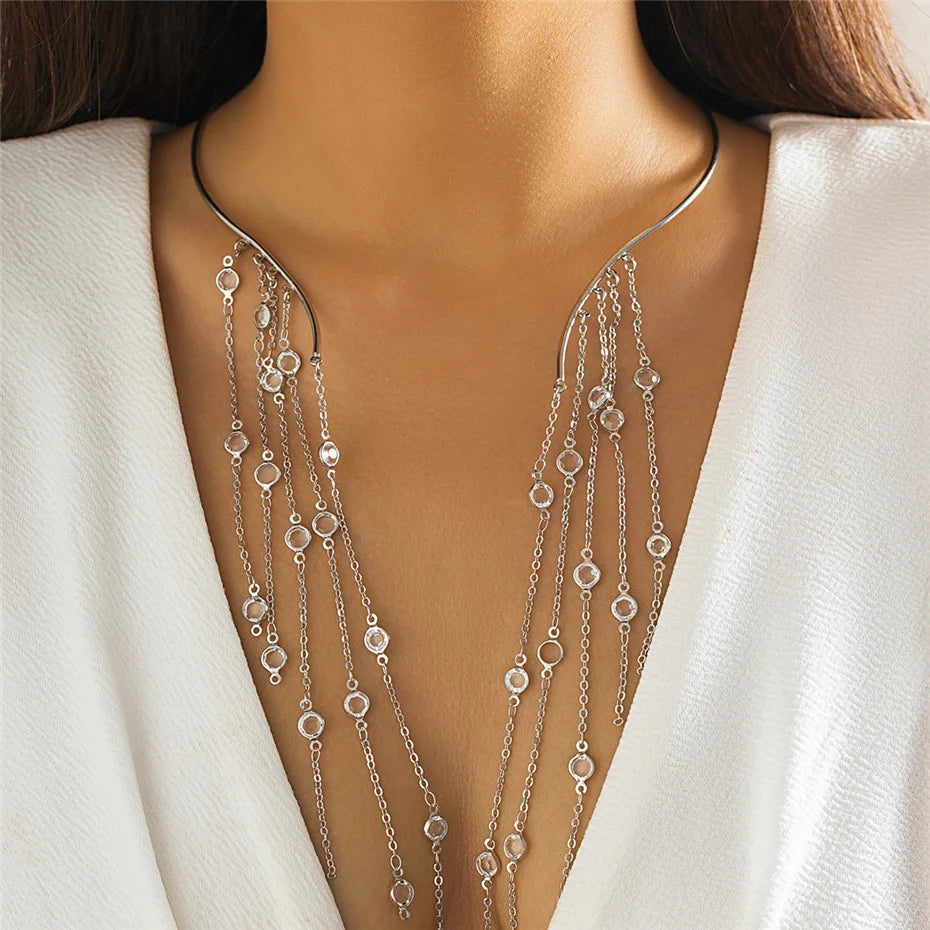 Silver necklace with dangling beads on a model wearing a white outfit