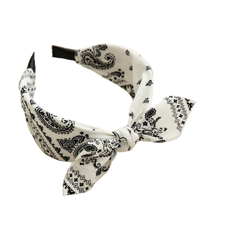 White headband with black paisley pattern on a beige tray