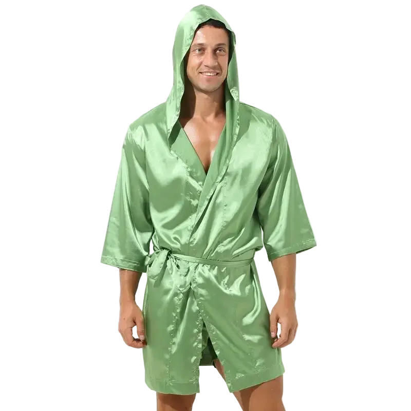 Man wearing a green satin robe with a hood on a white background