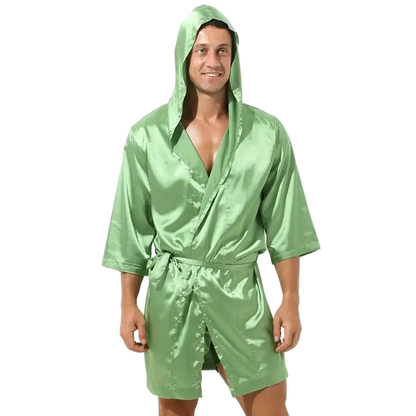Man wearing a green satin robe with a hood on a white background
