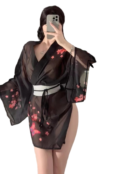 Person wearing a black kimono with pink floral patterns in front of a mirror.