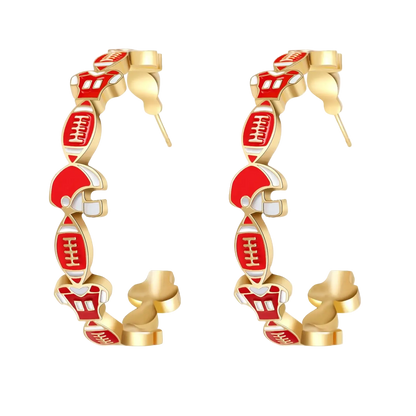 A pair of gold hoop earrings decorated with red and white football-themed charms, including helmets and footballs, shown on a white background with a soft reflection.
