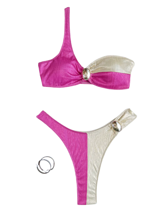 A bikini set with a one-shoulder design, featuring a combination of pink and cream colors. The pieces are accented with decorative gold rings.