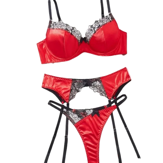 A three-piece red satin lingerie set with black lace trim and black straps, shown on a solid gray background.