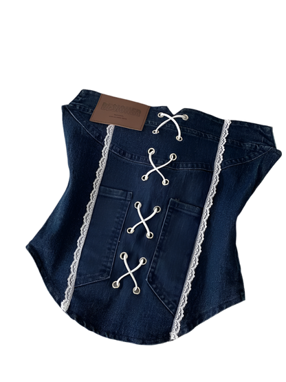 Denim corset with lace details on a white surface