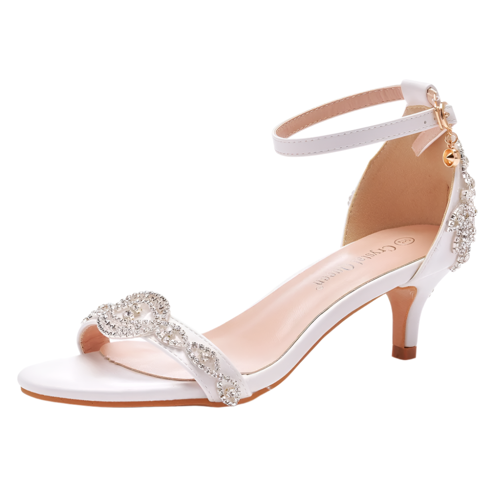 White high-heeled sandal with decorative straps on a white background