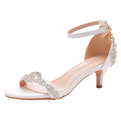 White high-heeled sandal with decorative straps on a white background