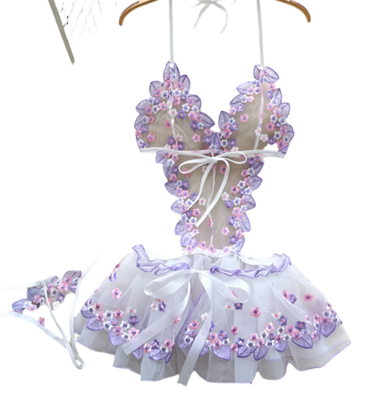 Children's floral bikini set on a hanger with flowers and a basket in the background