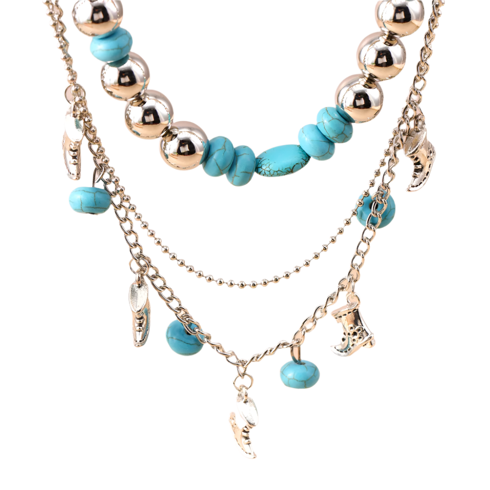 Layered necklace with turquoise beads and silver charms on a beige background