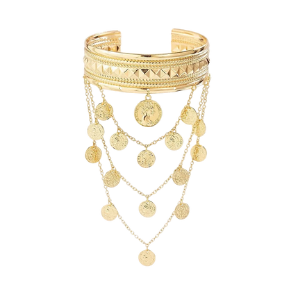 A gold-toned multi-strand cuff bracelet with geometric textured bands and multiple dangling coin-shaped chain charms, shown on a light cream background.