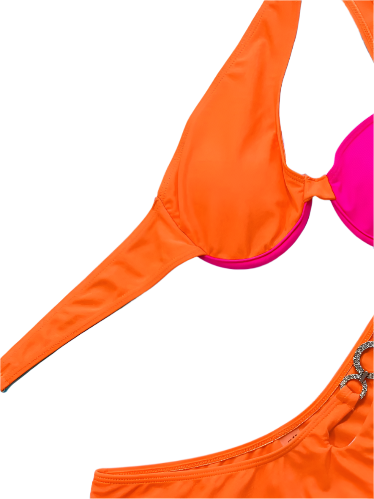 A two-tone bikini with orange and pink sections, featuring asymmetrical straps and jeweled embellishments. The design is vibrant and unique, perfect for a standout beach look.