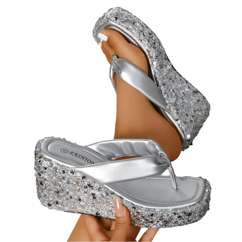Silver glittery sandal with platform sole on a wooden floor