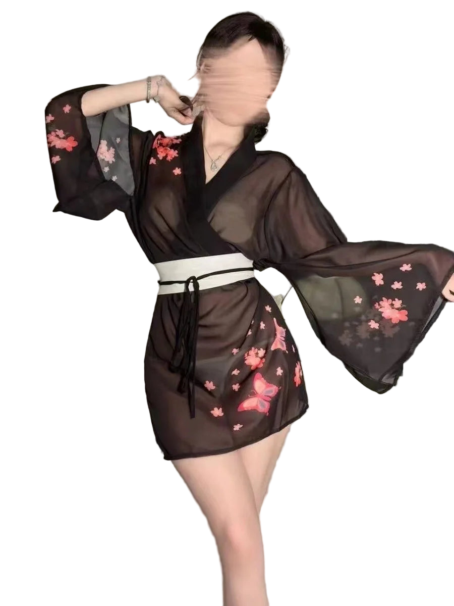 Person wearing a black sheer kimono with pink floral patterns in a bedroom setting.