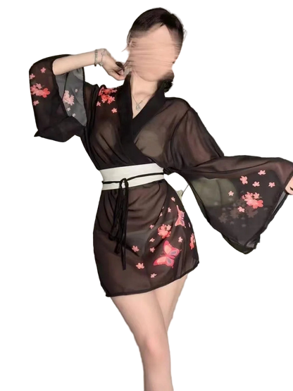 Person wearing a black sheer kimono with pink floral patterns in a bedroom setting.