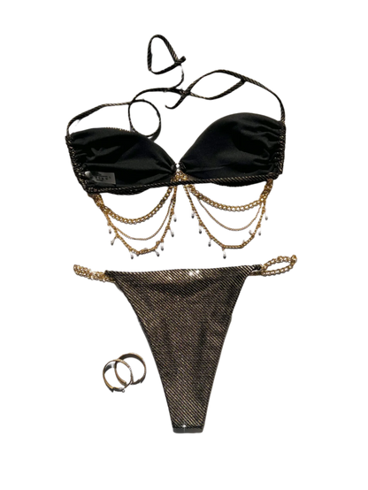 A glamorous black bikini with a metallic sheen, adorned with gold chain embellishments. The set includes a bandeau top and matching bottoms, offering a luxurious and stylish appearance.